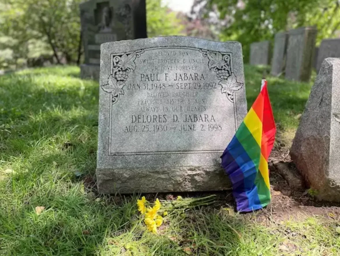 A small tombstone with a LGBT rainbow flag.