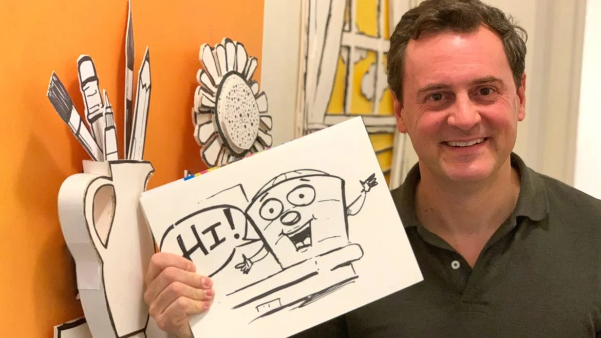 A photo of Jeff Hopkins holding up a sketch of the Guggenheim.