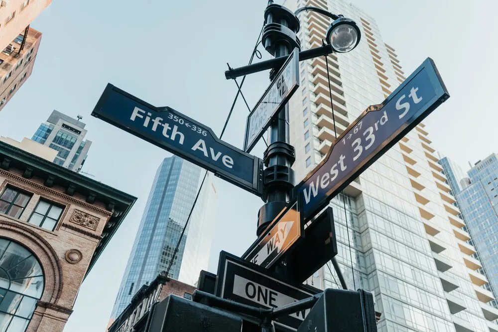 Image looking up at the street signage at the intersection of Fifth Avenue and 33rd Street