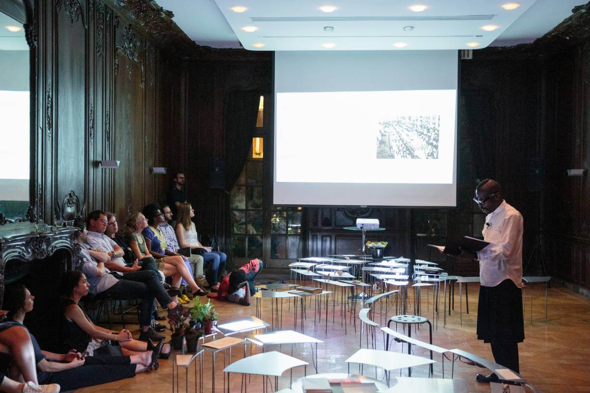 Image of a room with attendees watching Mario Gooden speak