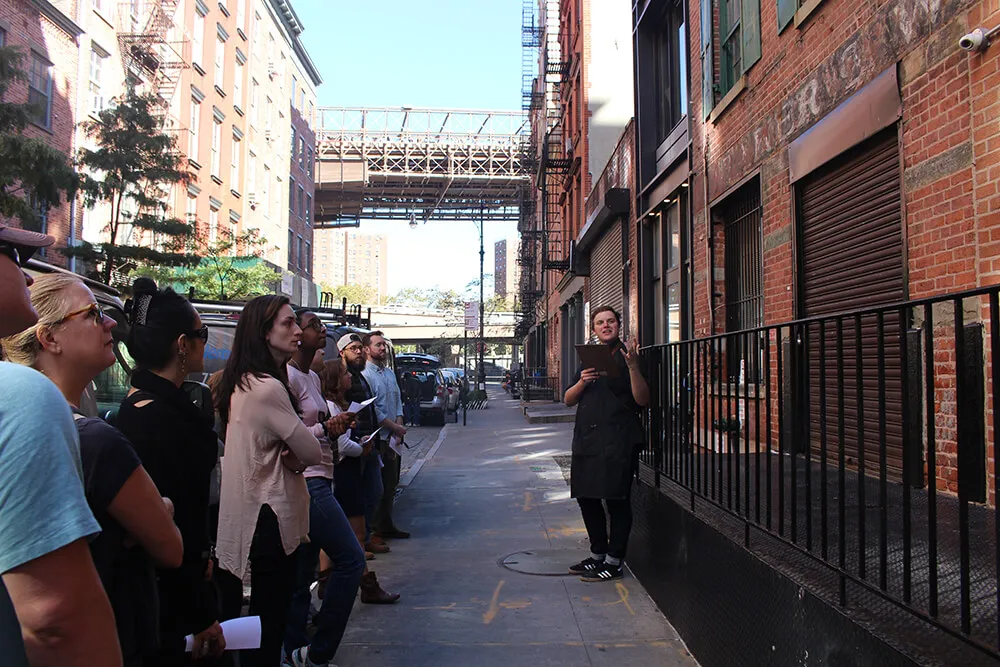 View of a street with a tour guide speaking to a group of attendees