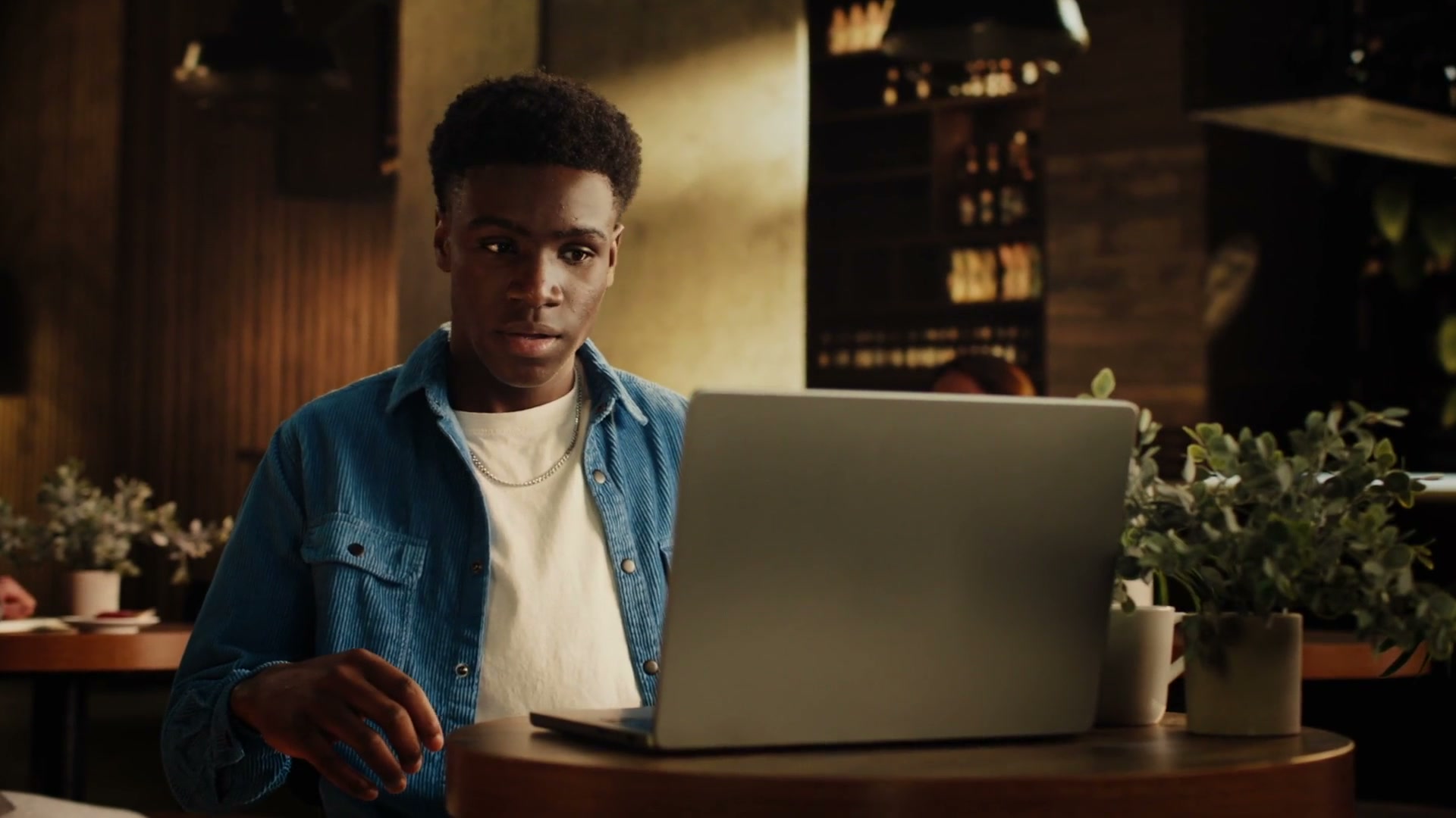 BPP Defy Your Limits, the reality world, Ben in a cafe before a digital portal disrupts his frame.