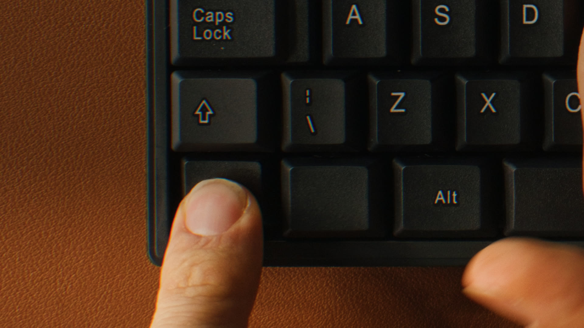 Macro close-up of a black mechanical keyboard with the Ctrl key prominent and thumb hovering.