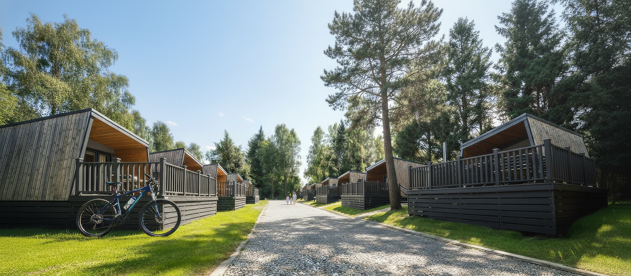 AI-generated photoreal lakeside Sykes lodges at dusk, illuminated by interior lamps