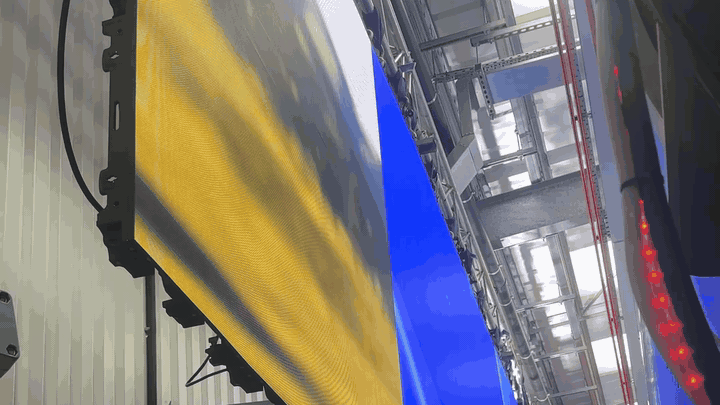 BTS — Tungsten's LED panel walls displaying a sky-and-landscape composite (yellow sun + blue sky), Werner yellow A-ladder centre frame, red rope-lights overhead