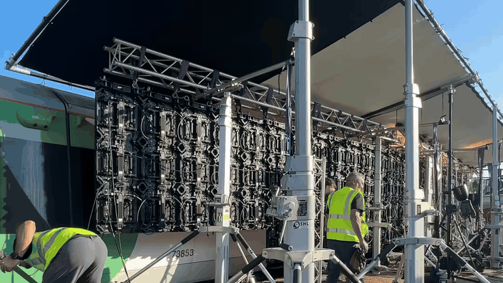 BTS — outdoor LED panel volume set up alongside Southern train carriage 73053 in the depot, production scale and cabling visible