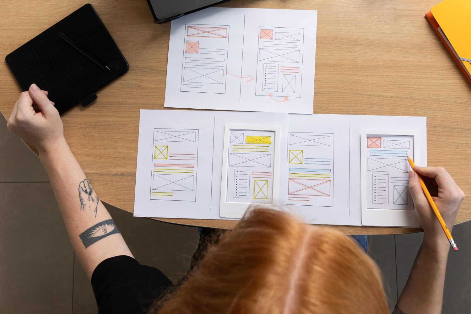 Projektantka analizująca i rysująca makietę strony internetowej w procesie UX design.