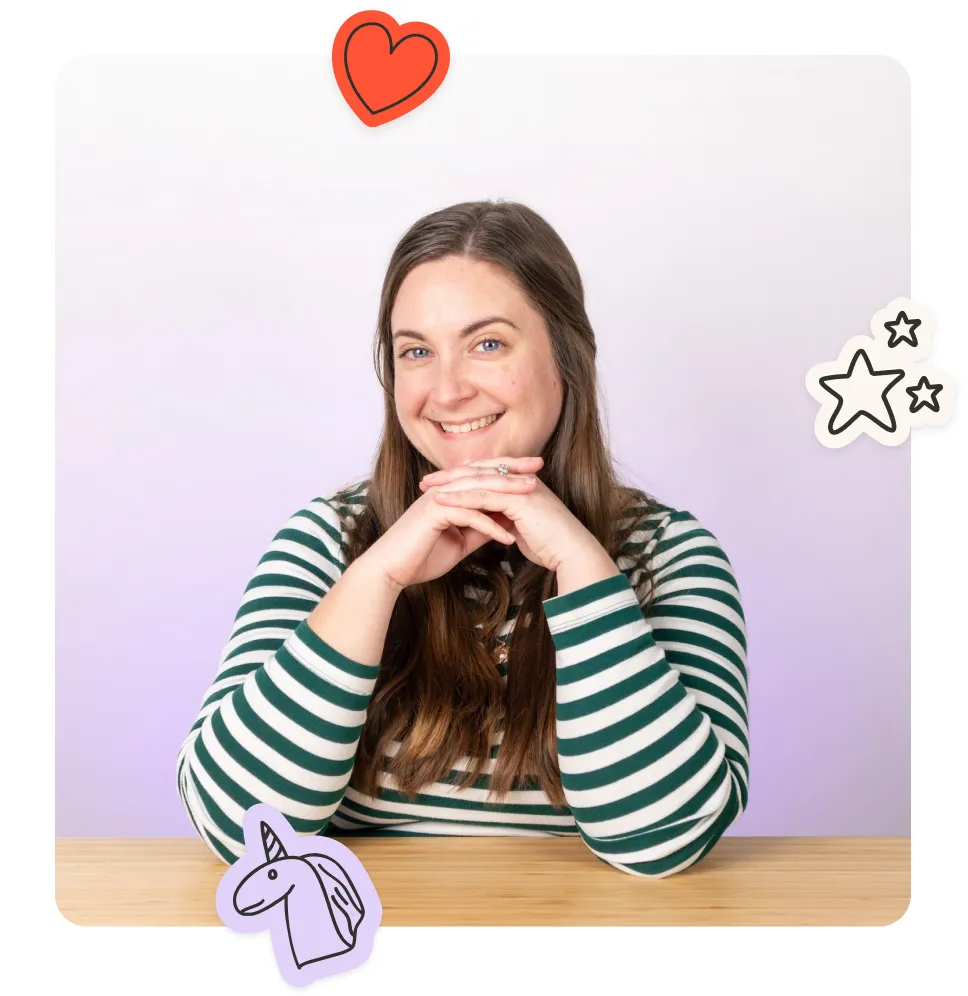 Meghan, Head of Marketing US, smiling warmly at the camera with hands clasped, wearing a green and white striped long-sleeve shirt, seated at a wooden desk against a soft purple gradient background with playful illustrated stickers of a heart, stars, and a unicorn.