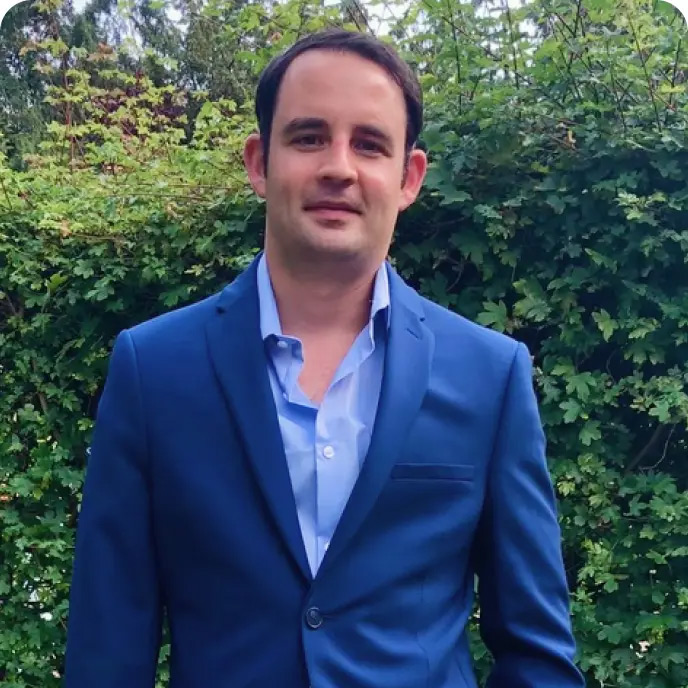 Ben Bausor wearing a blue suit outdoors in a garden
