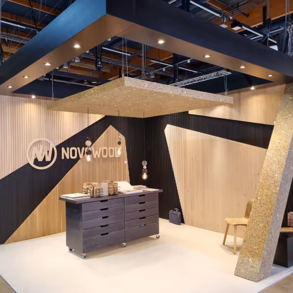 Luomispisteen suunnittelema Novowoodin messuosasto, jonka seinät on rakennettu puumateriaalista ja jossa on esillä yrityksen logo ja työpöytä.