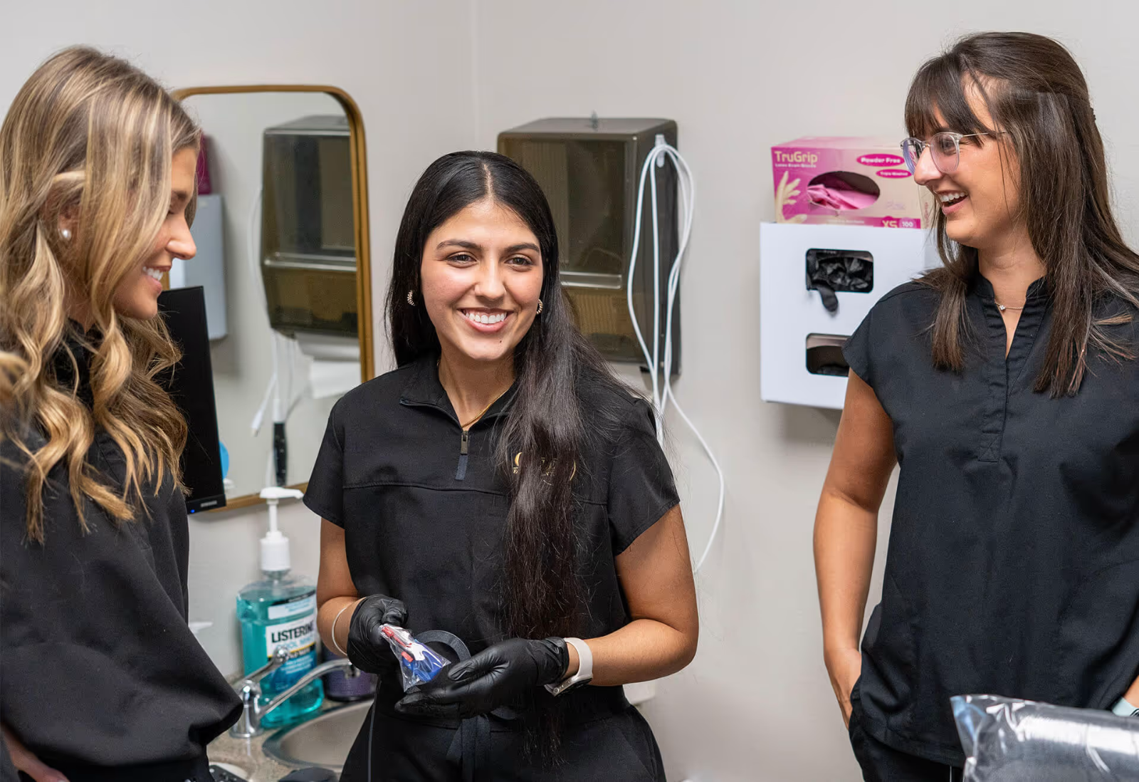 Accelerated Academy students in black scrubs in a dental office