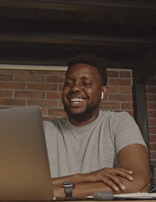 A person smiling at a laptop