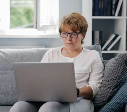 A person sitting on a couch using a laptop
