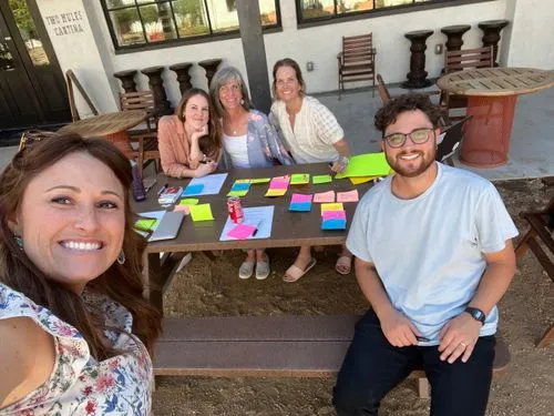 A group of people sitting at a table with post-it notes
