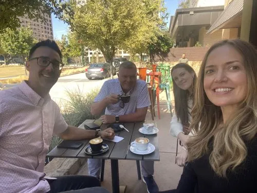 A group of people sitting at a table with coffee cups