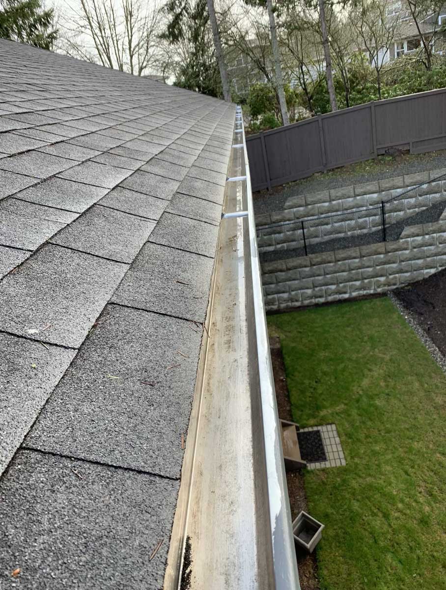 View of clean gutters on left above yard on right.