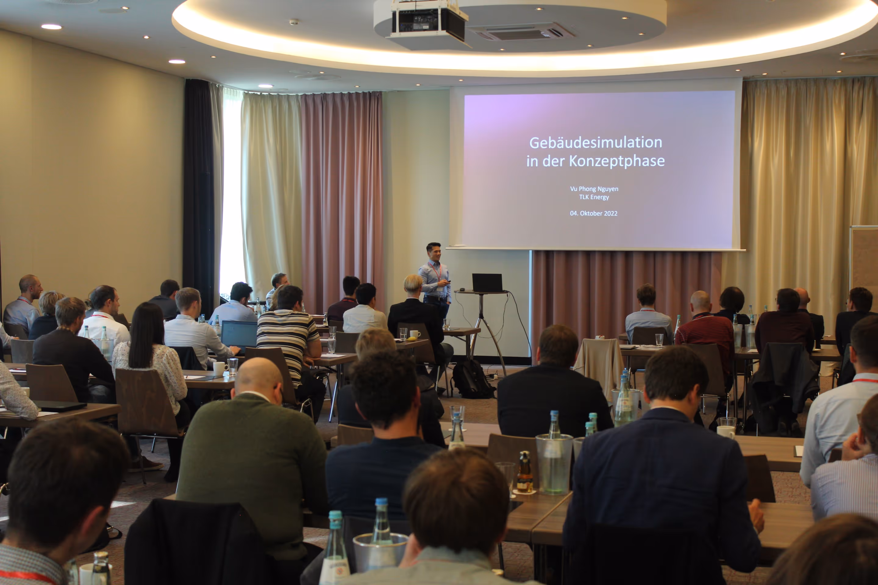 Cup of black coffee on a saucer next to a plate with a slice of crumb cake and a fork on a wooden table.