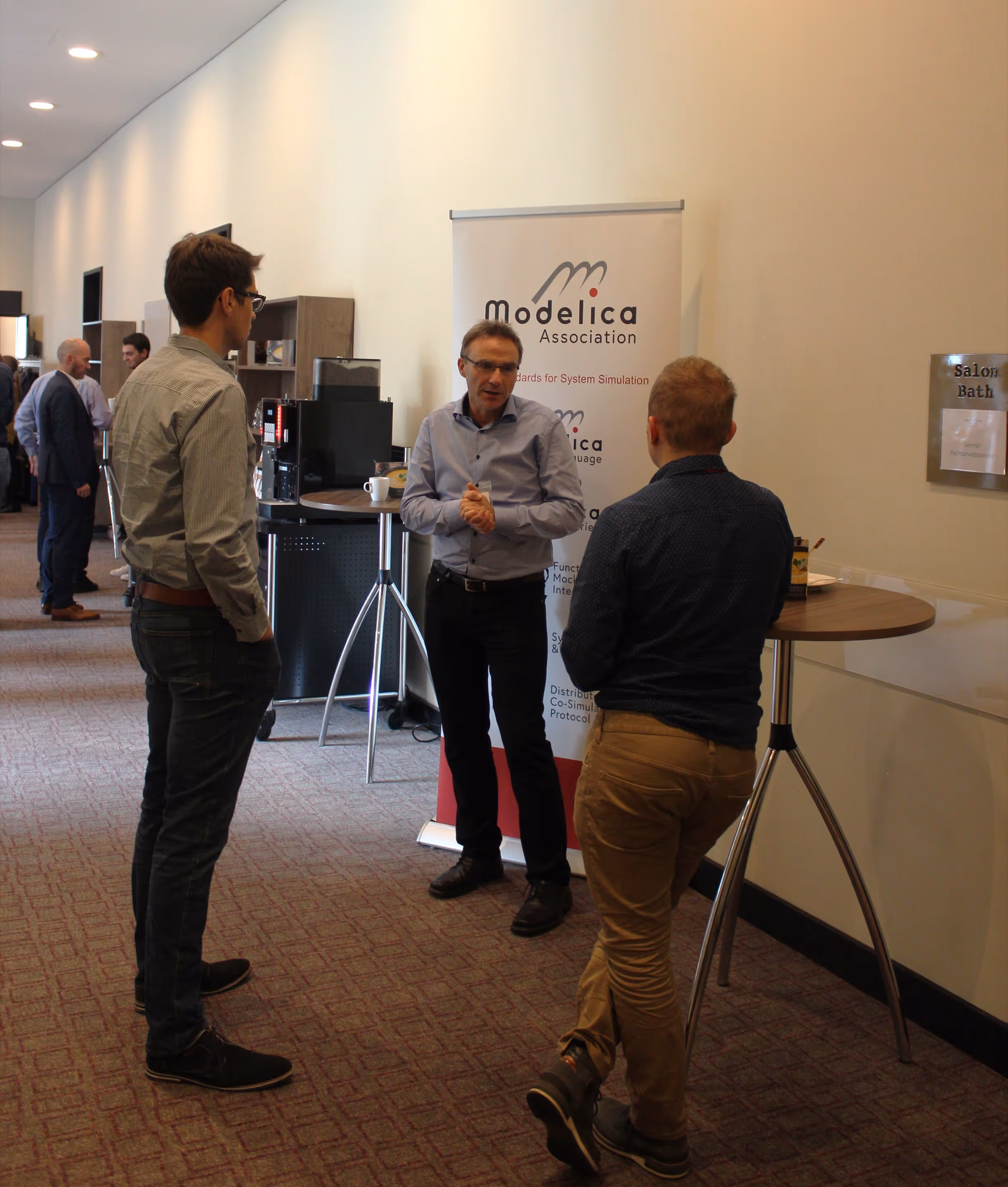 Catering trays with assorted wrap sandwiches and mini quiches arranged neatly with serving tongs.