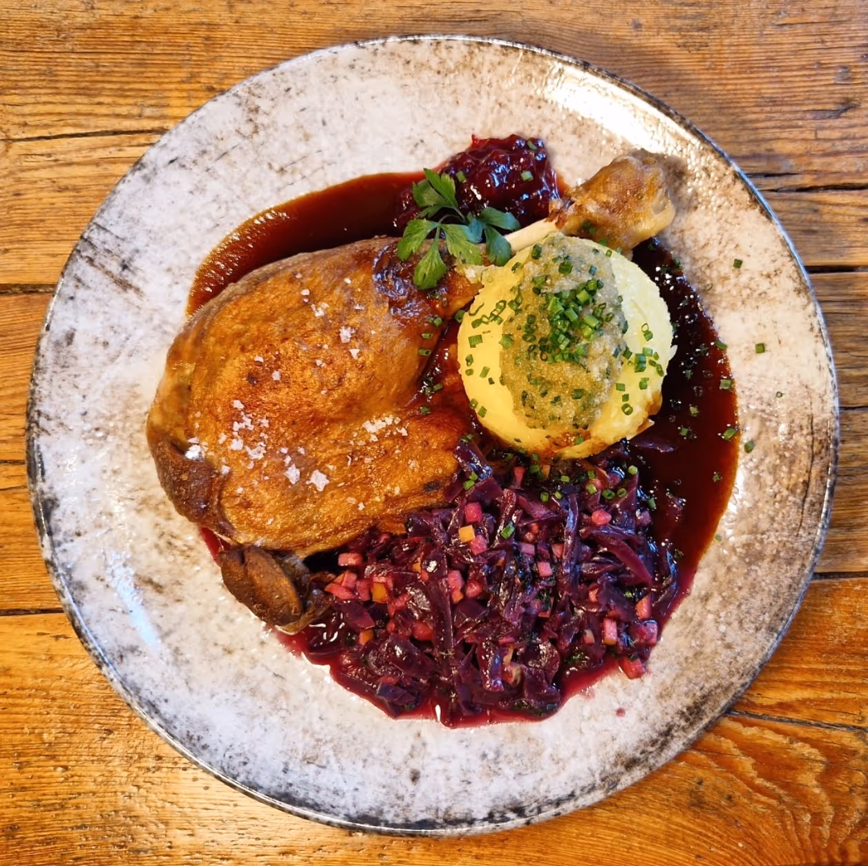 Two hands clinking tall glasses of light beer with foam in a warm, blurred background.