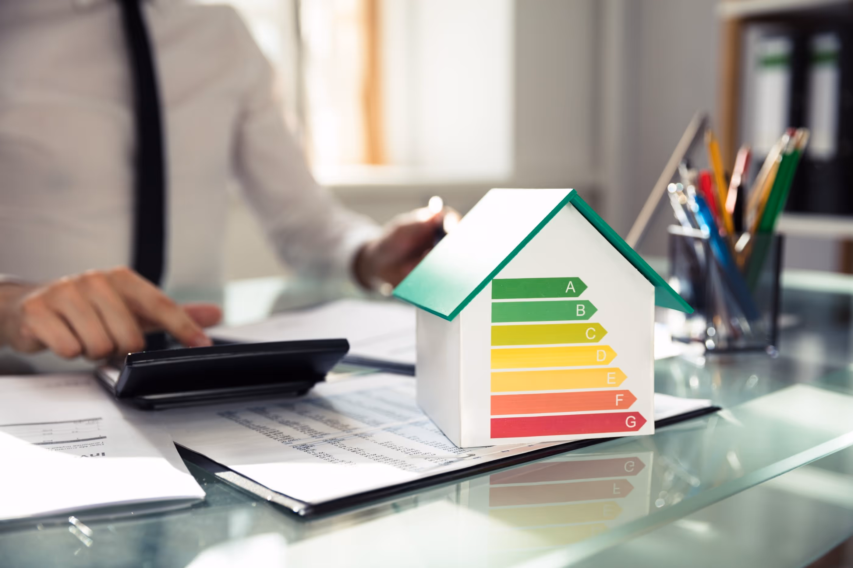 Photo d'une personne faisan des analyse pour l'efficacité énergétique d'une maison, avec une échelle de ABCDEFG pour un CECB