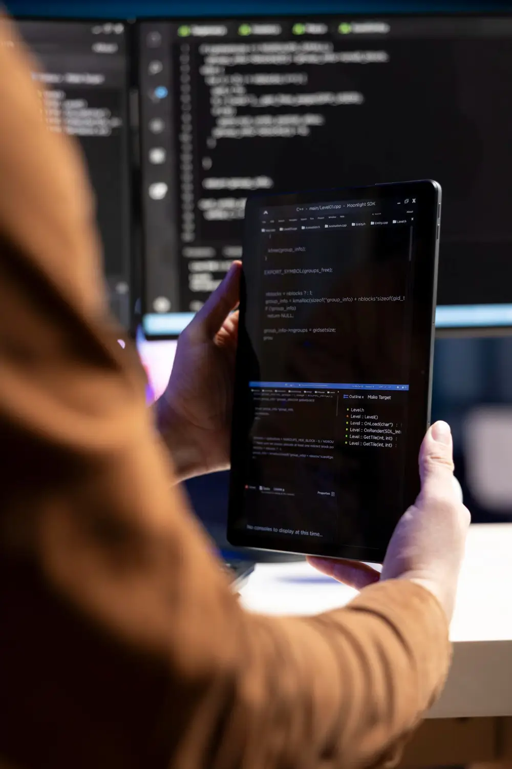 Developer reviewing code on a tablet in a software development workspace