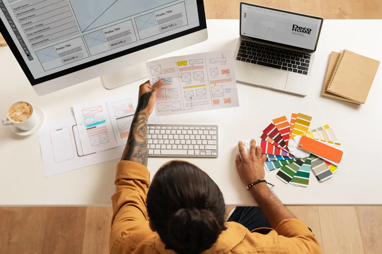 Graphic designer workspace with laptop, desk lamp, and color swatches