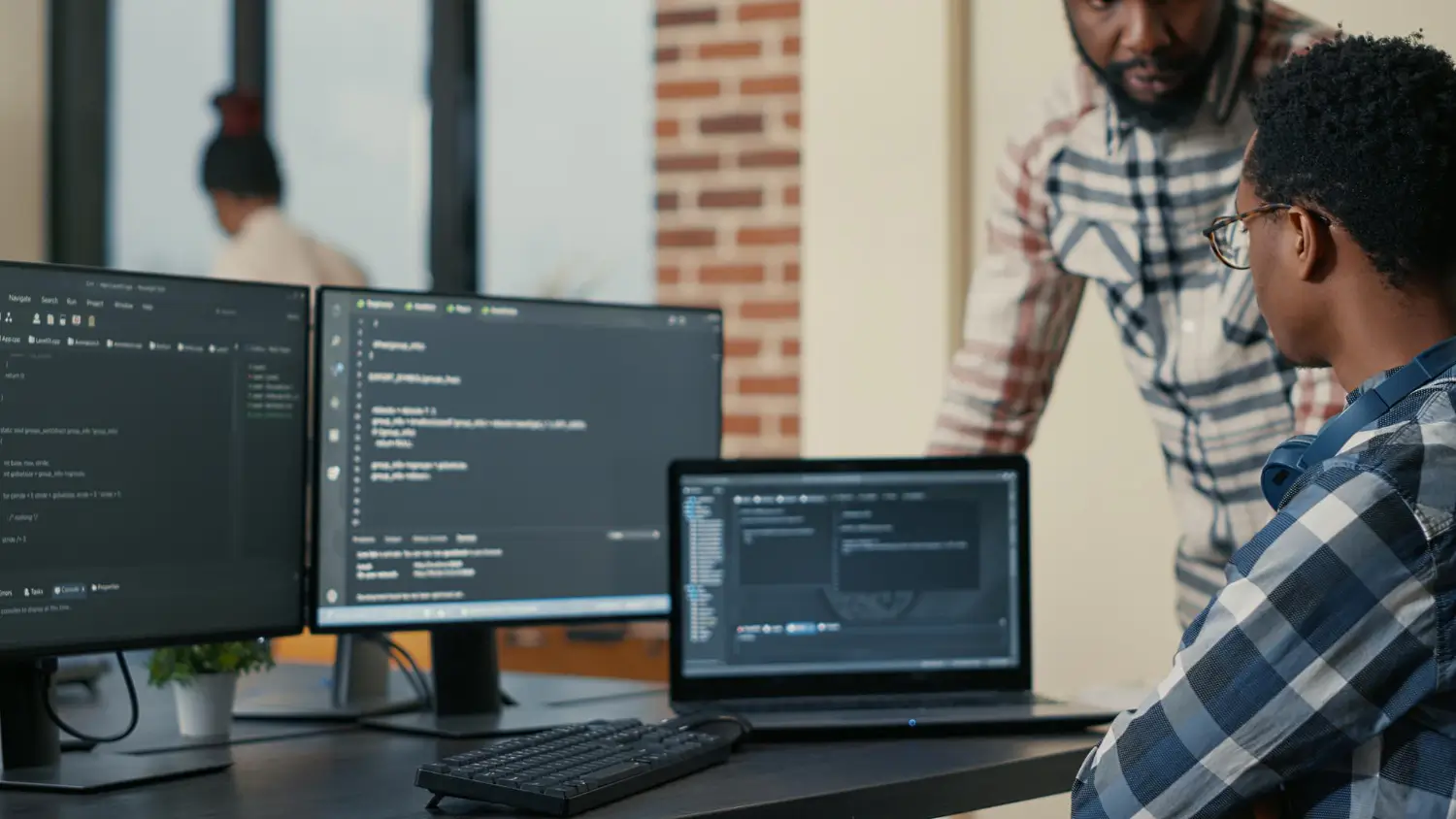 Web developer working with code on multiple computer screens