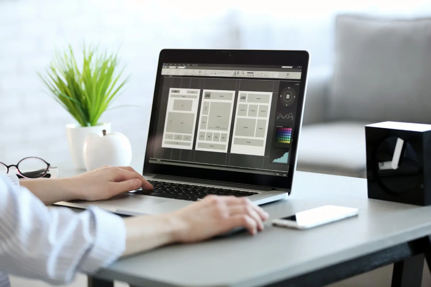 Website design and UI wireframes displayed on a laptop during the design process