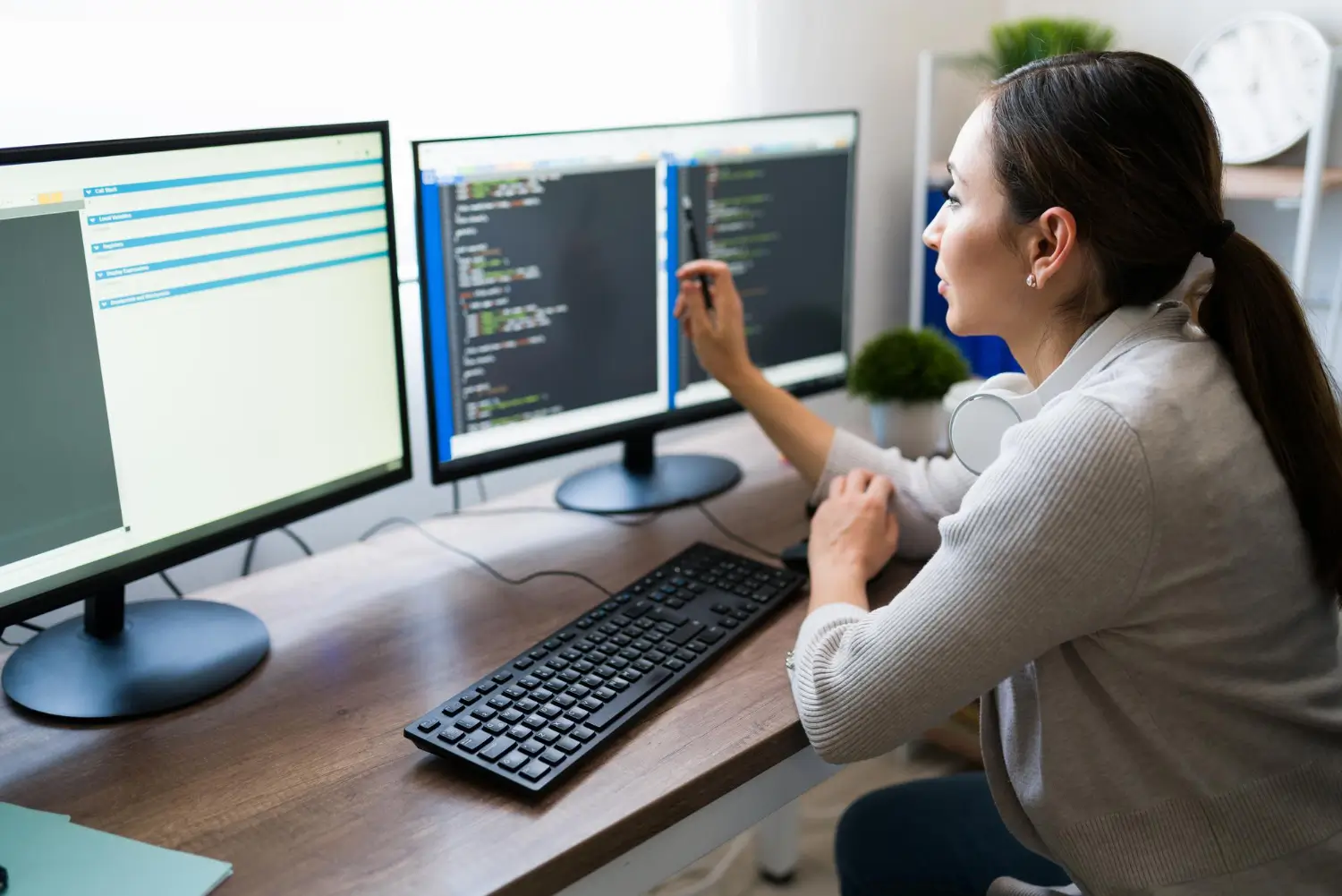 Website audit and development review with code and website interface on multiple screens