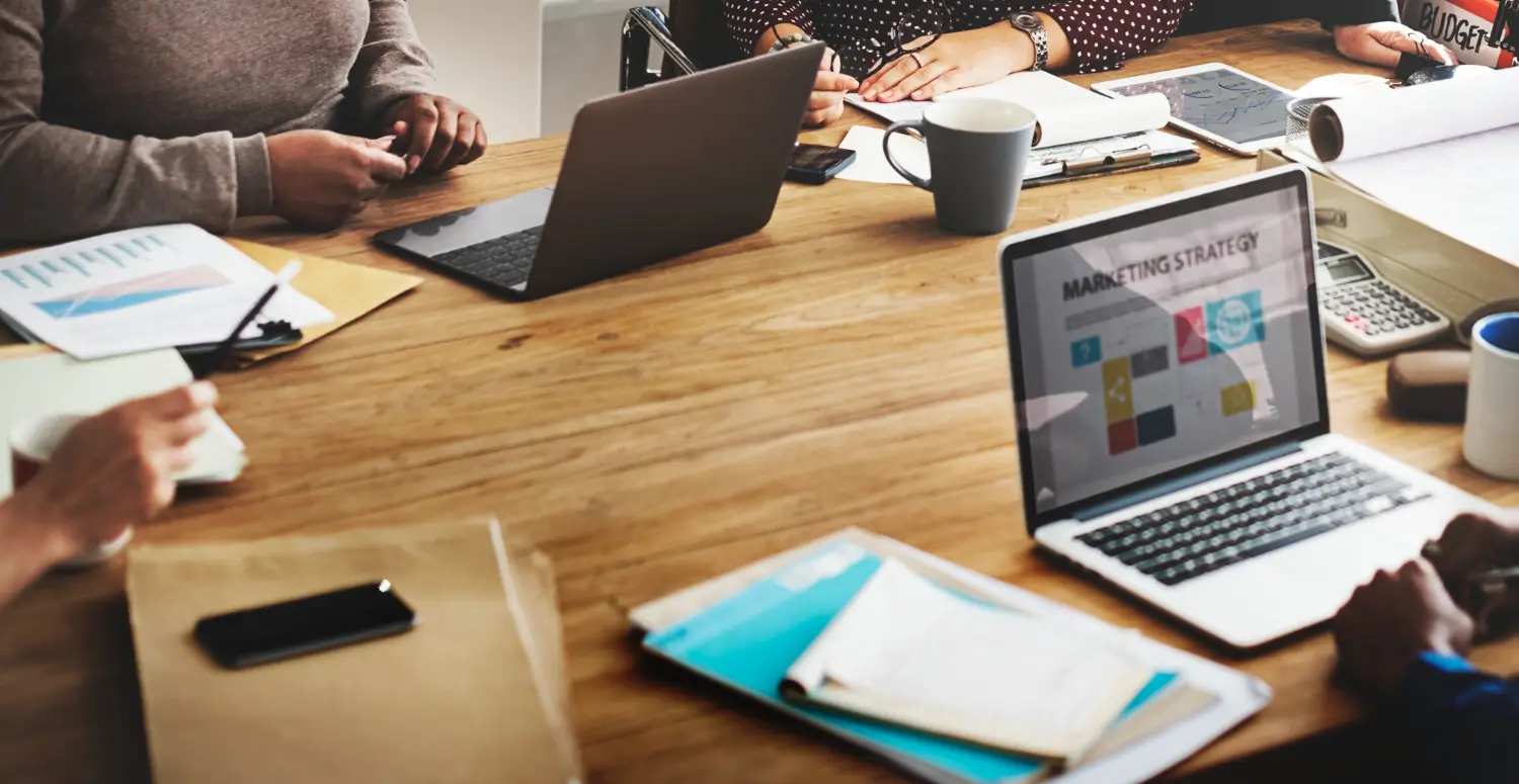 Digital marketing strategy meeting with marketing plans and laptop
