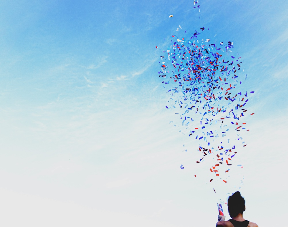 woman shooting confetti into the sky