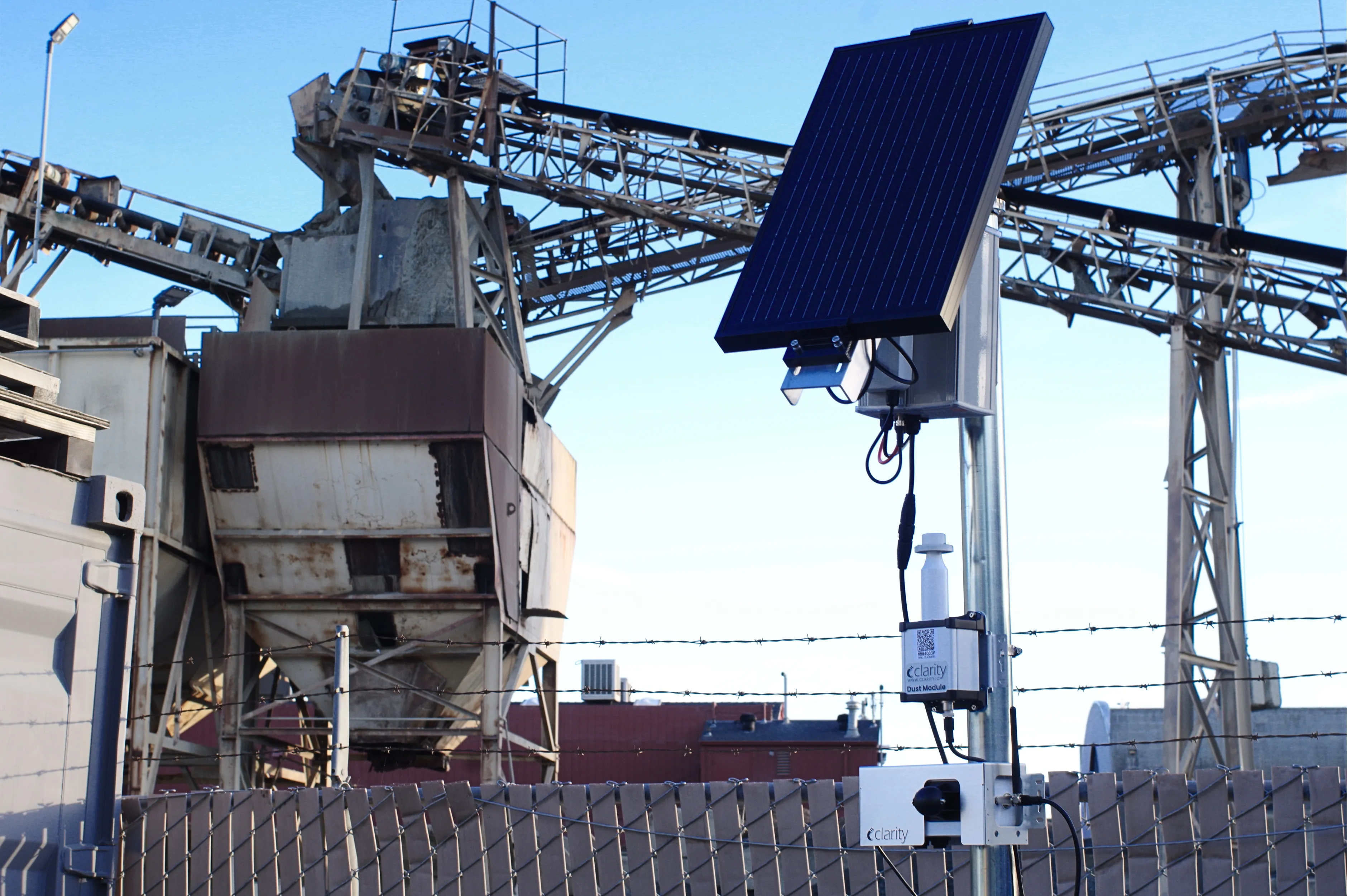 Optionally solar-powered Dust Module air quality sensor integrated with Clarity Node-S delivering near-reference PM10 accuracy; the best solar-ready PM10 measurement solution on the market, shown measuring dust air pollution in front of a cement plant.