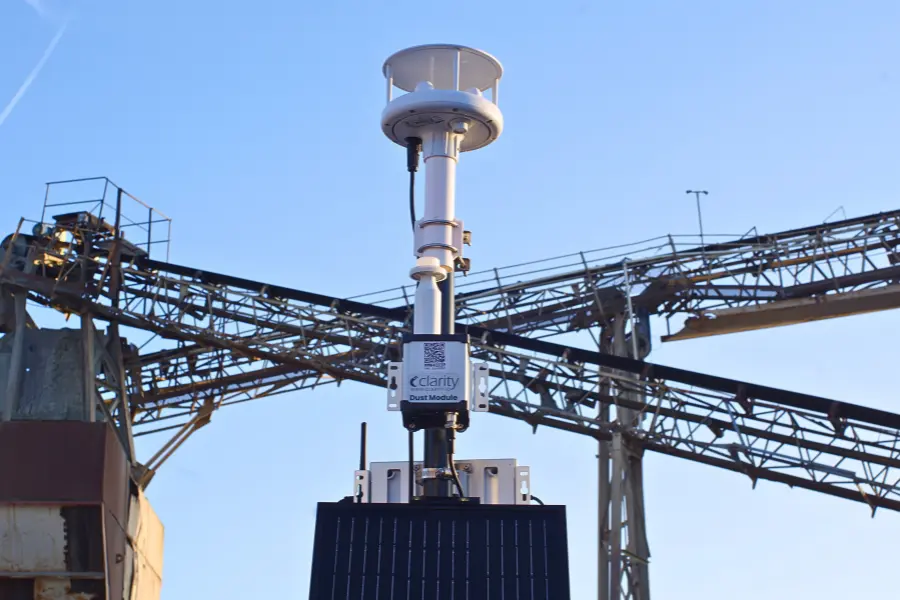 Optionally solar-powered Dust Module air quality sensor integrated with Clarity Node-S delivering near-reference PM10 accuracy; the best solar-ready PM10 measurement solution on the market, shown measuring dust air pollution in front of a cement plant.