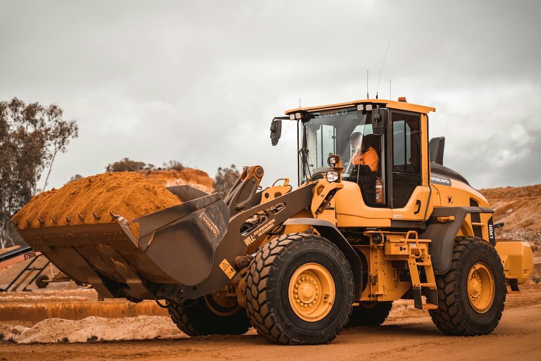 Image of an industrial tractor transporting dirt and producing particulate matter dust air pollution (PM10). 