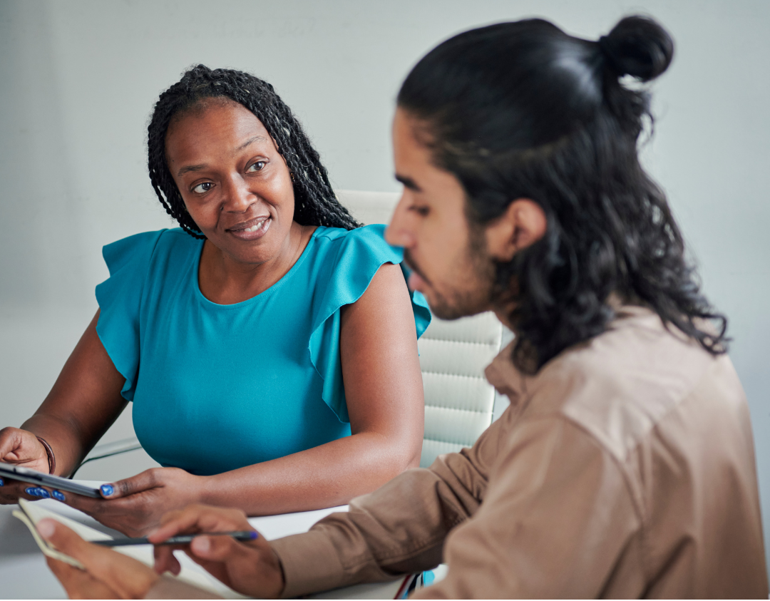 Woman sitting at a table talking with a man