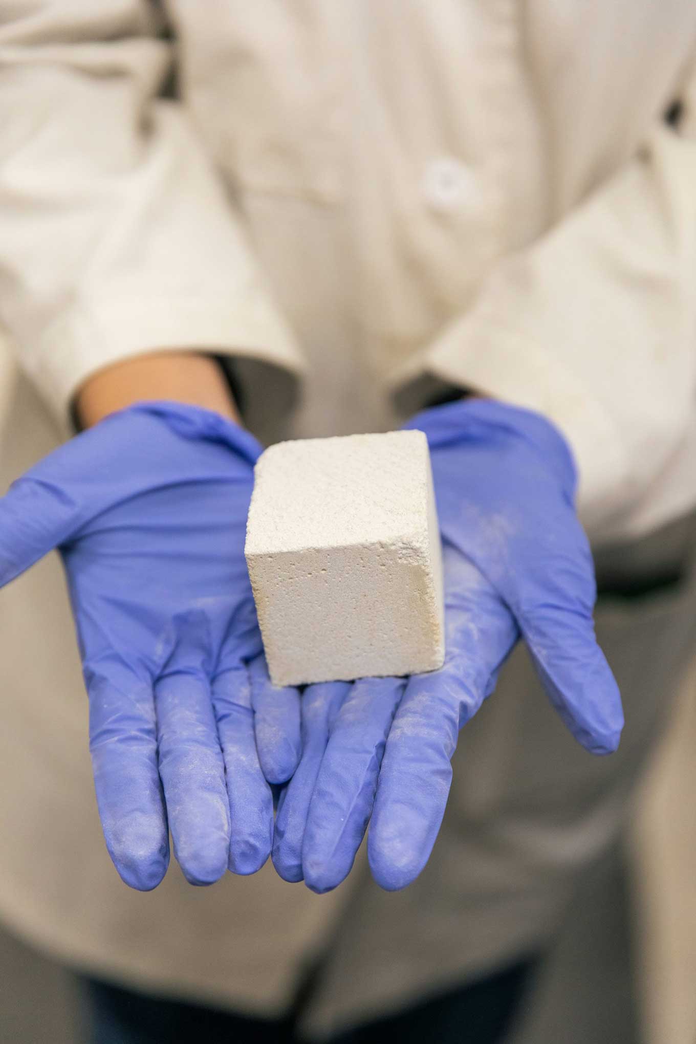 Person holding a pure low-carbon cement binder in their hands