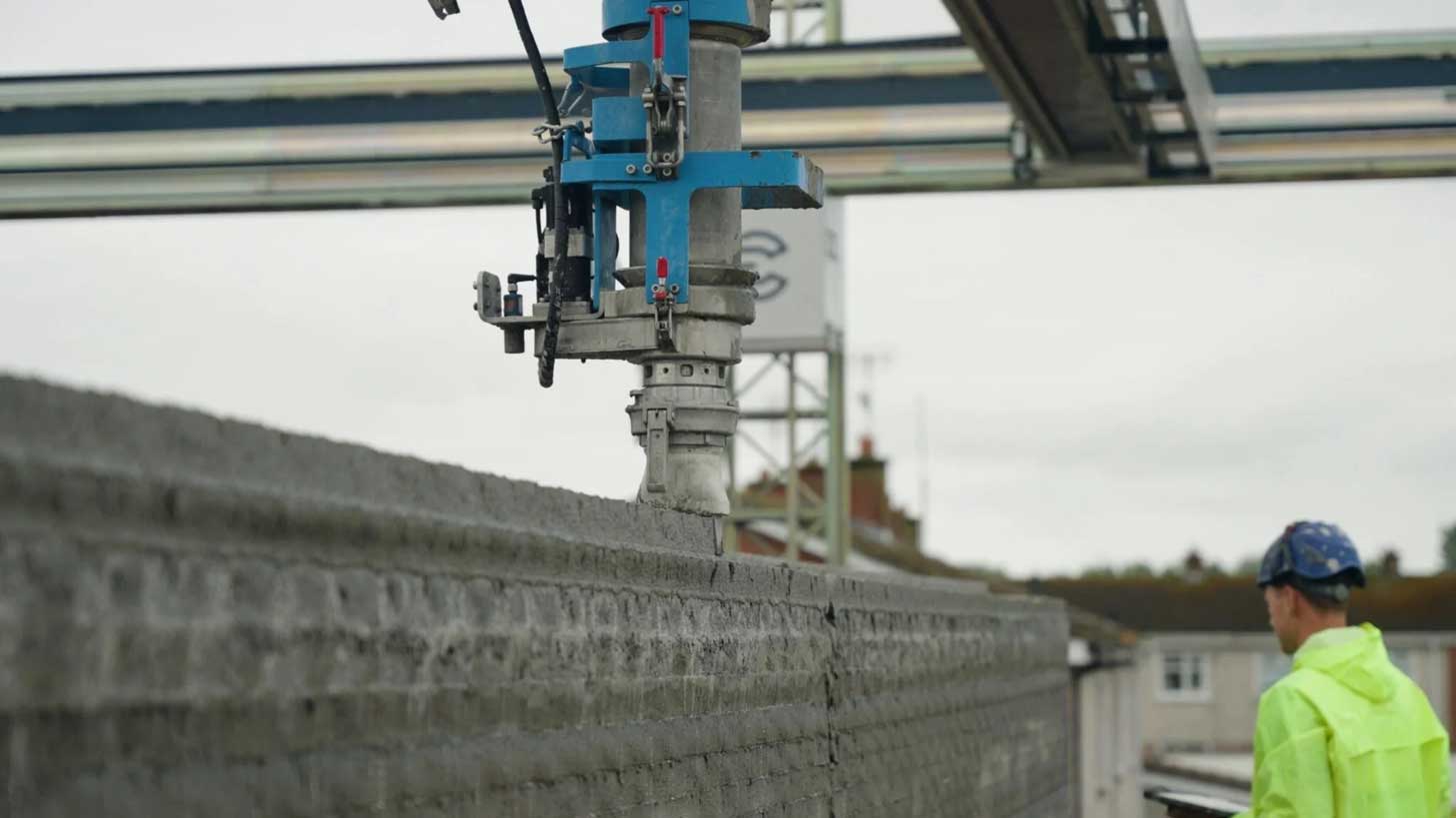 A 3D printer assembles concrete walls of an affordable housing development in Ireland