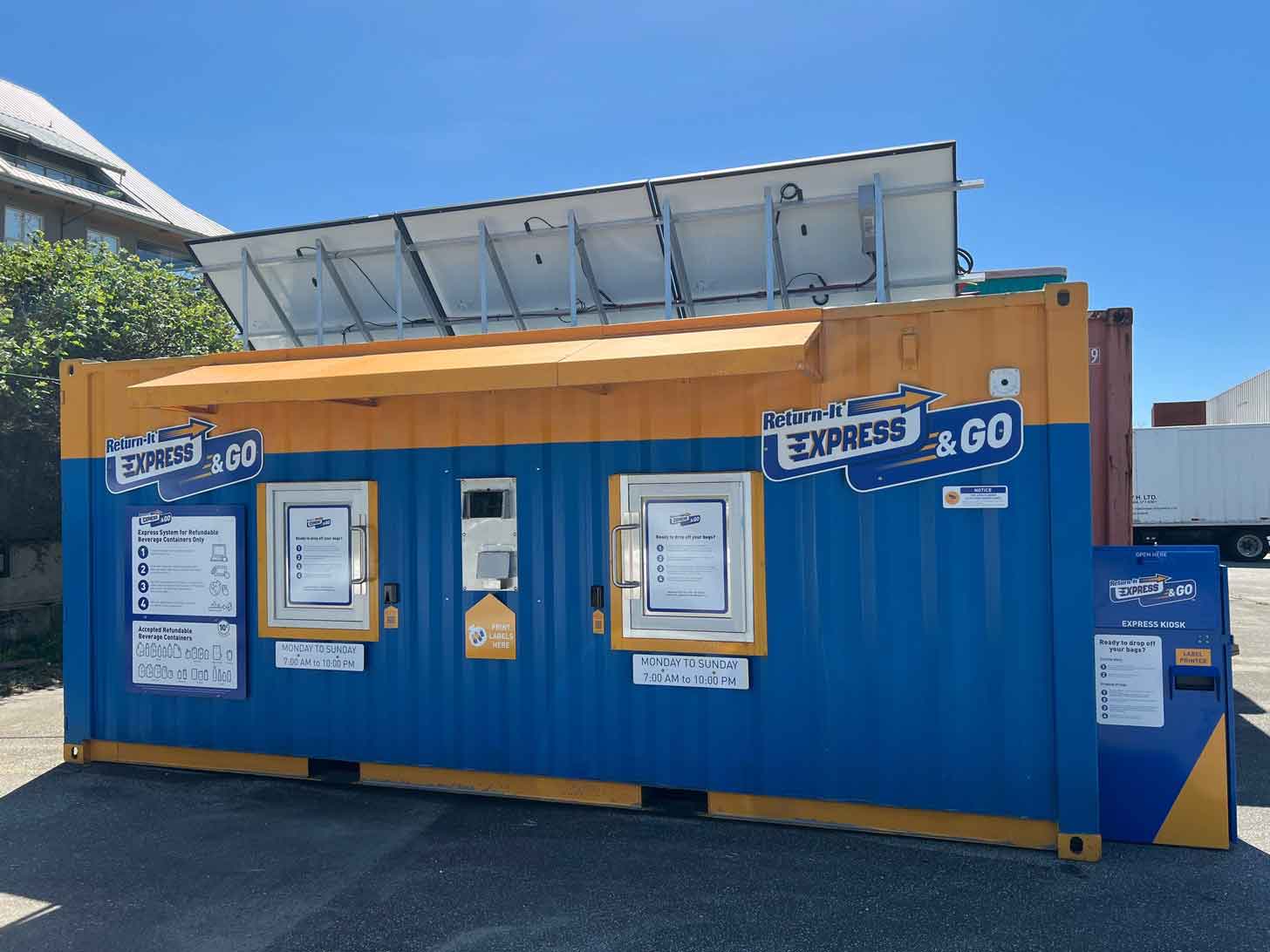 A shipping container painted blue and yellow offers a station for people to recycle bottles and cans in exchange for money in Canada.