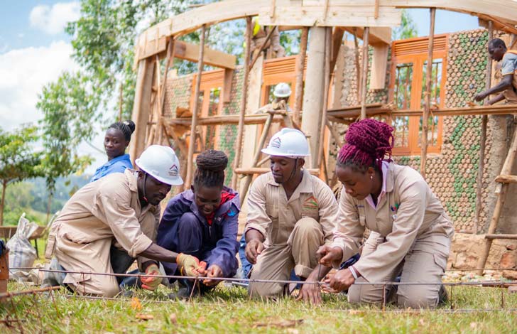 Four people in Uganda help build a home