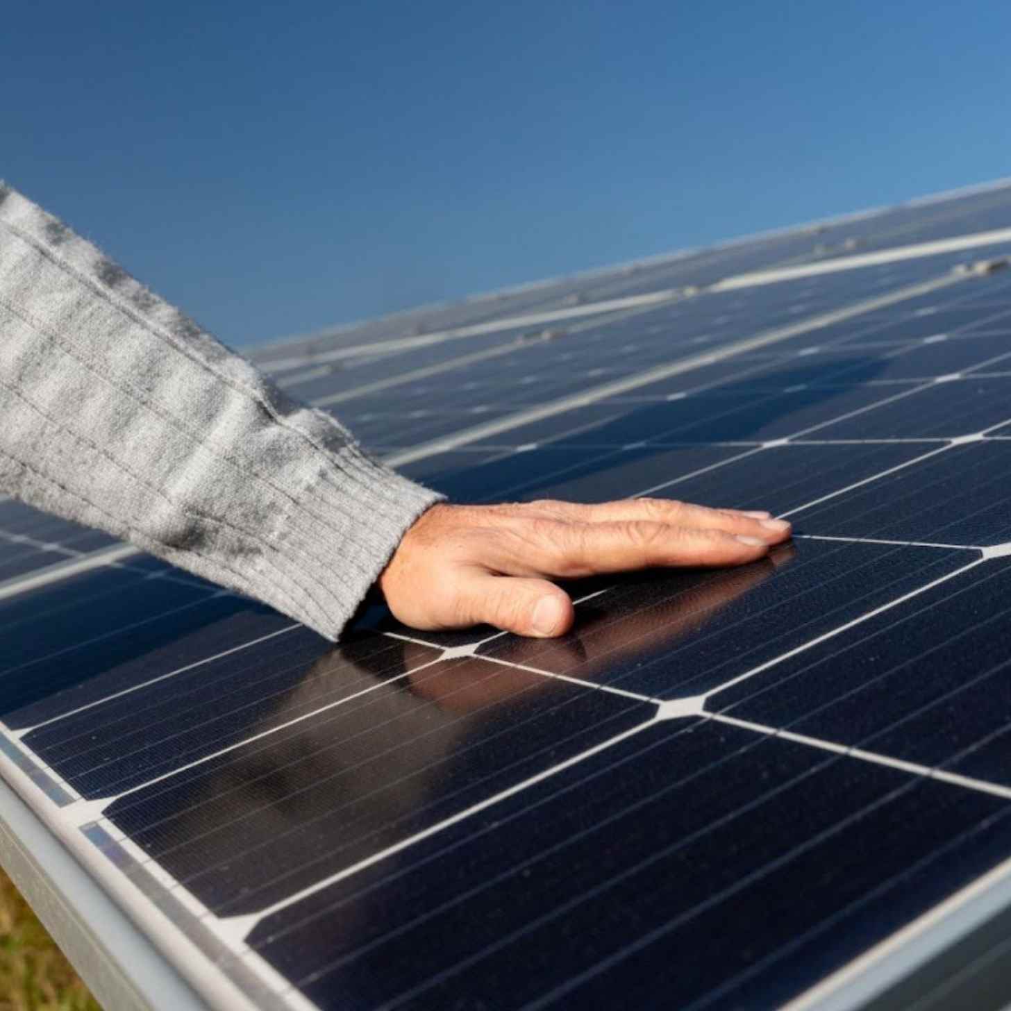 A hand resting on a solar panel