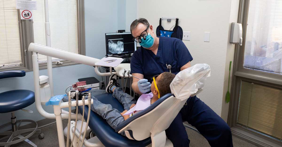 A dentist works on a patient in their office