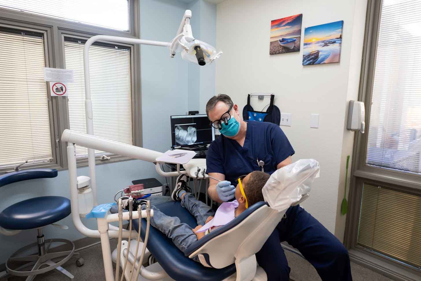 A dentist works on a patient in their office