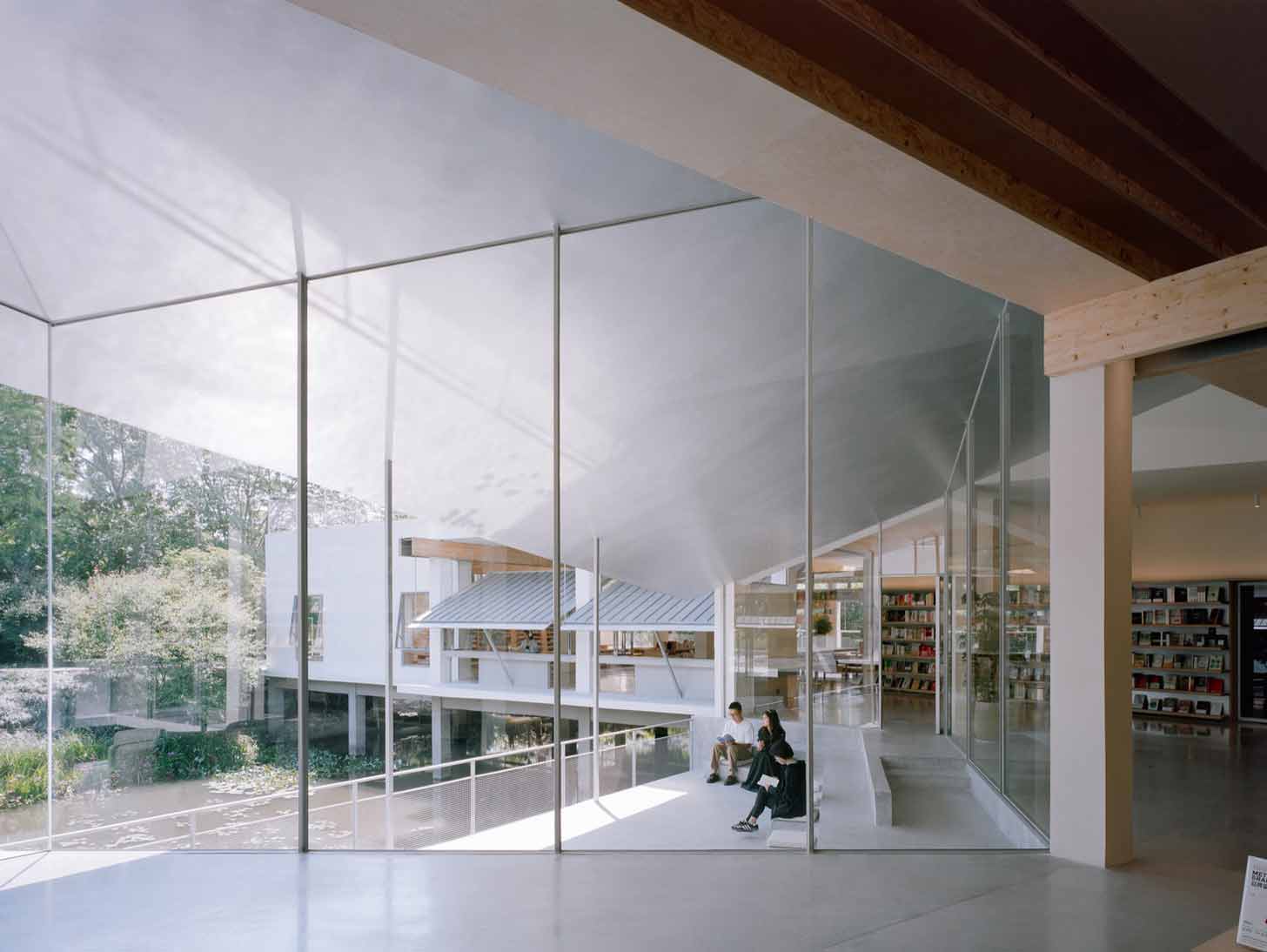 Bookstore visitors sit in a sunken pavilion overlooking wetlands in China