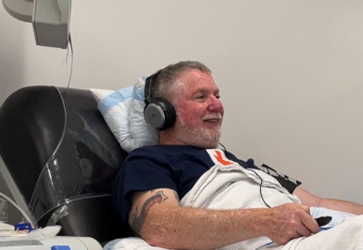A 62-year-old man sits in a bed donating platelets for the American Red Cross