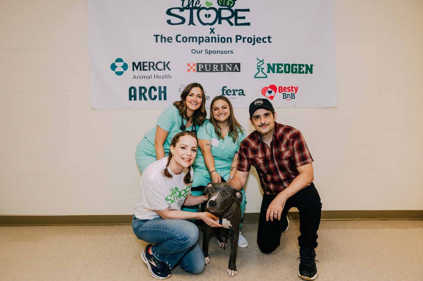 Kimberly Williams-Paisley, two veterinarians, and Brad Paisley, smile while petting a gray pit bull