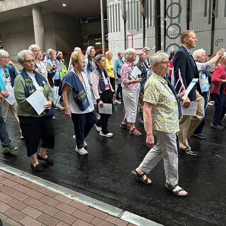 A group of older Catholic sisters walk through the streets of downtown Atlanta