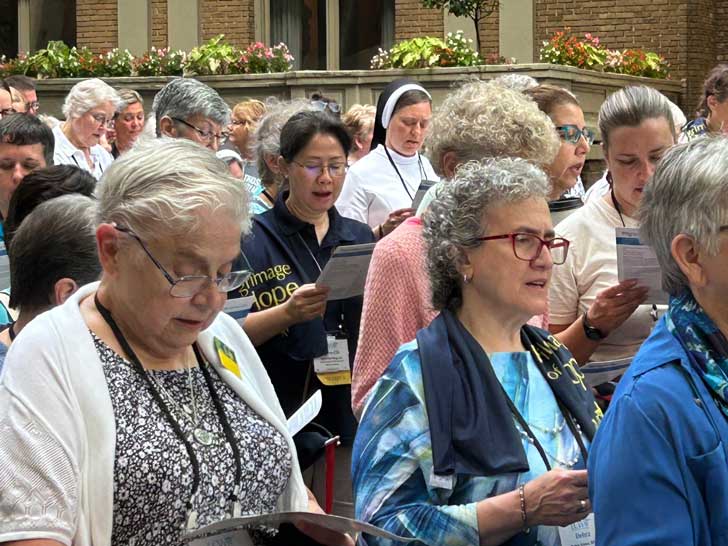 A group of elderly women reads from a prayer booklet