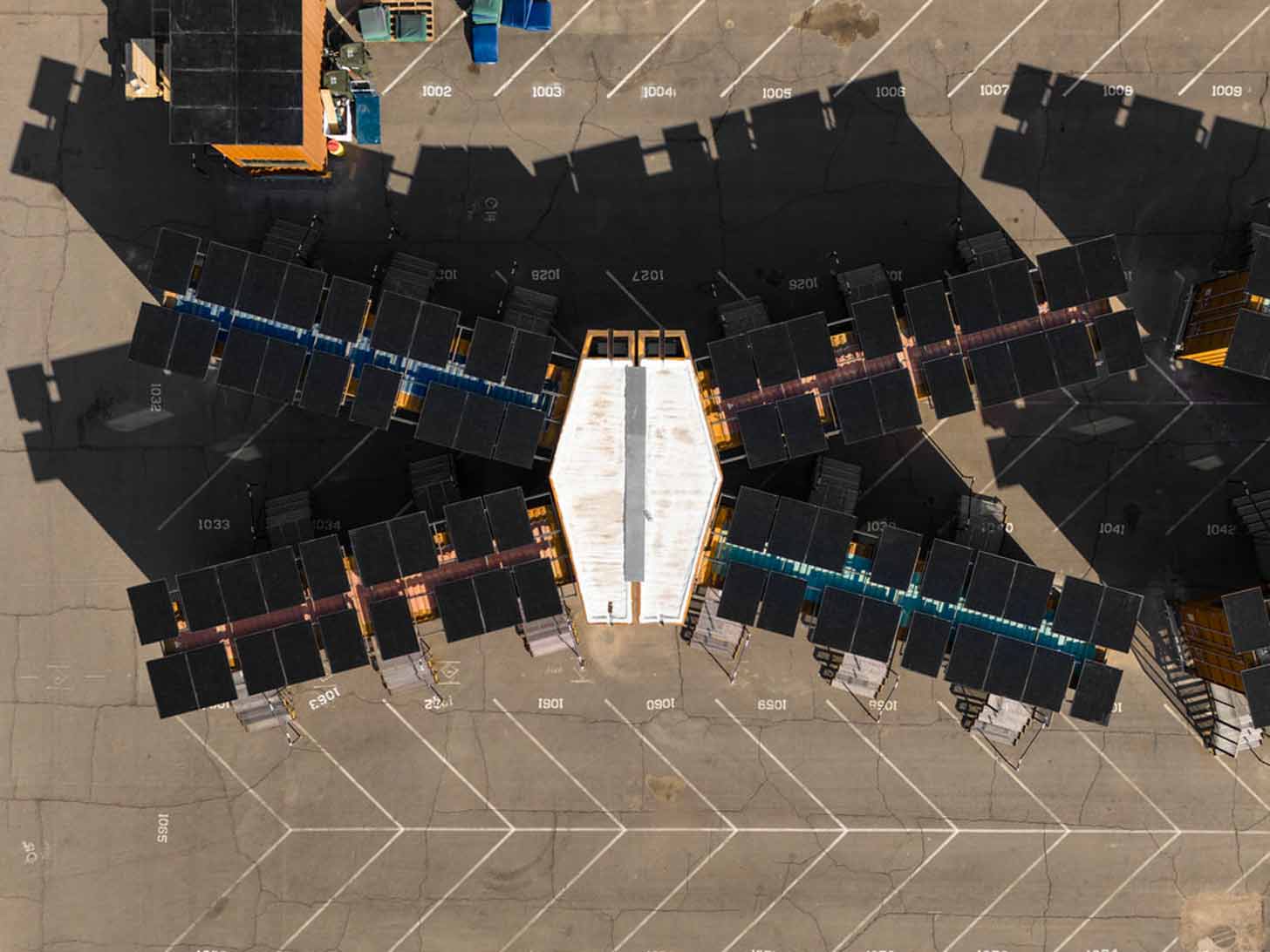 An aerial view of an X-shaped facility made of shipping containers