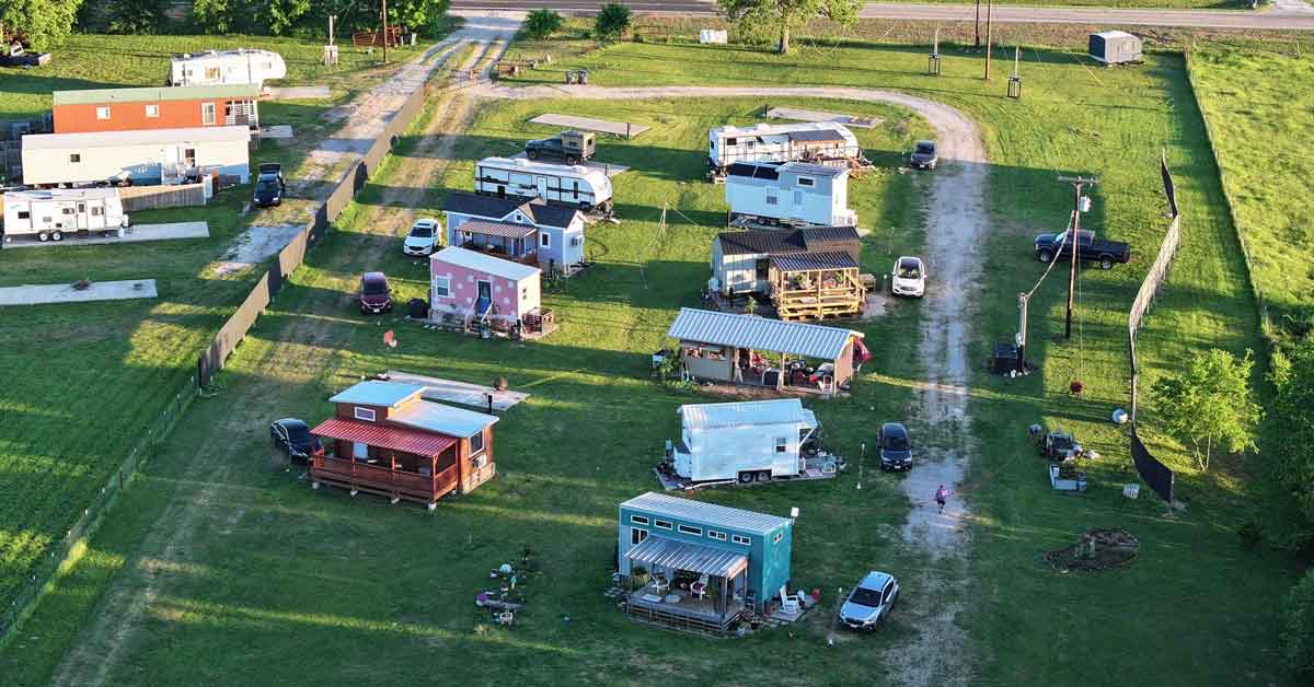 An aerial view of a tiny home neighborhood on a plot of green land in Texas