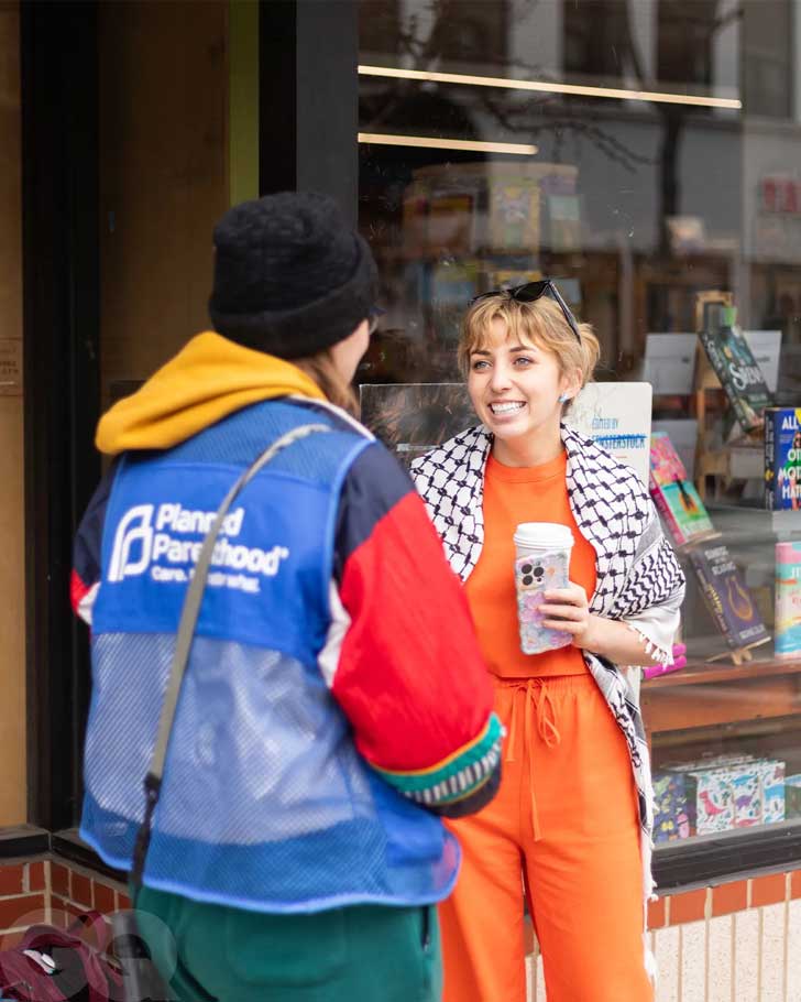 Kat Abughazaleh speaks to a person in a Planned Parenthood vest outside of a bookstore in Illinois